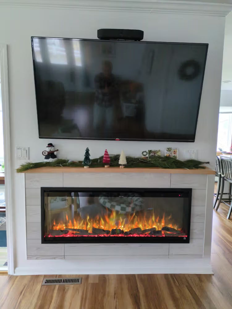 Electric fireplace with decorative mantel and TV above in a living room setting.