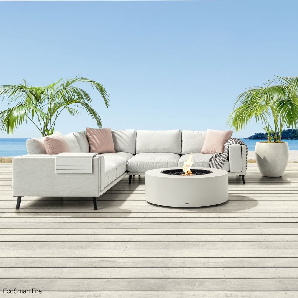 EcoSmart Fire Ark 39-Inch Round Concrete Fire Pit Table on a deck with beach view