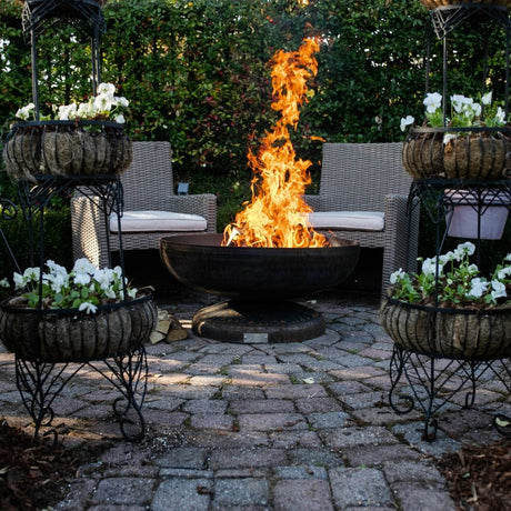 Seasons Fire Pits Vulcan Round Steel Fire Pit in a garden
