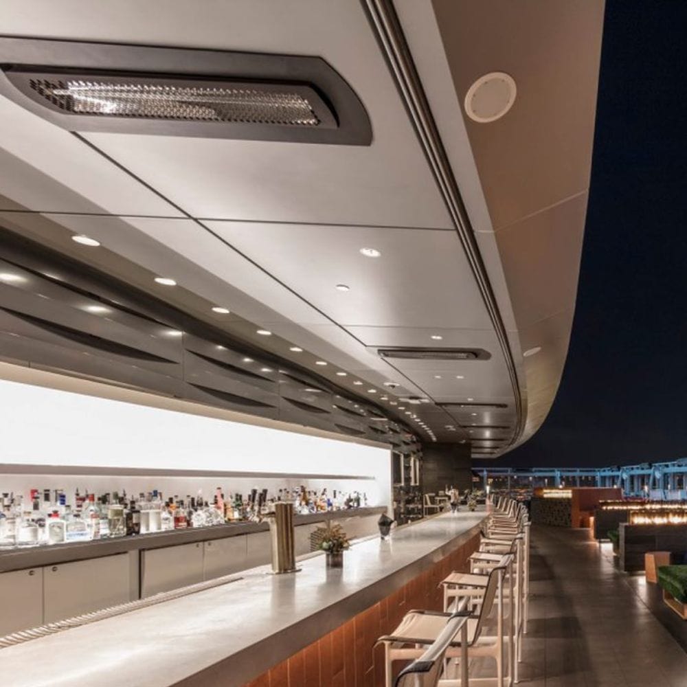 Black bromic tungsten smart-heat black electric patio heater flush mounted at a bar outdoors