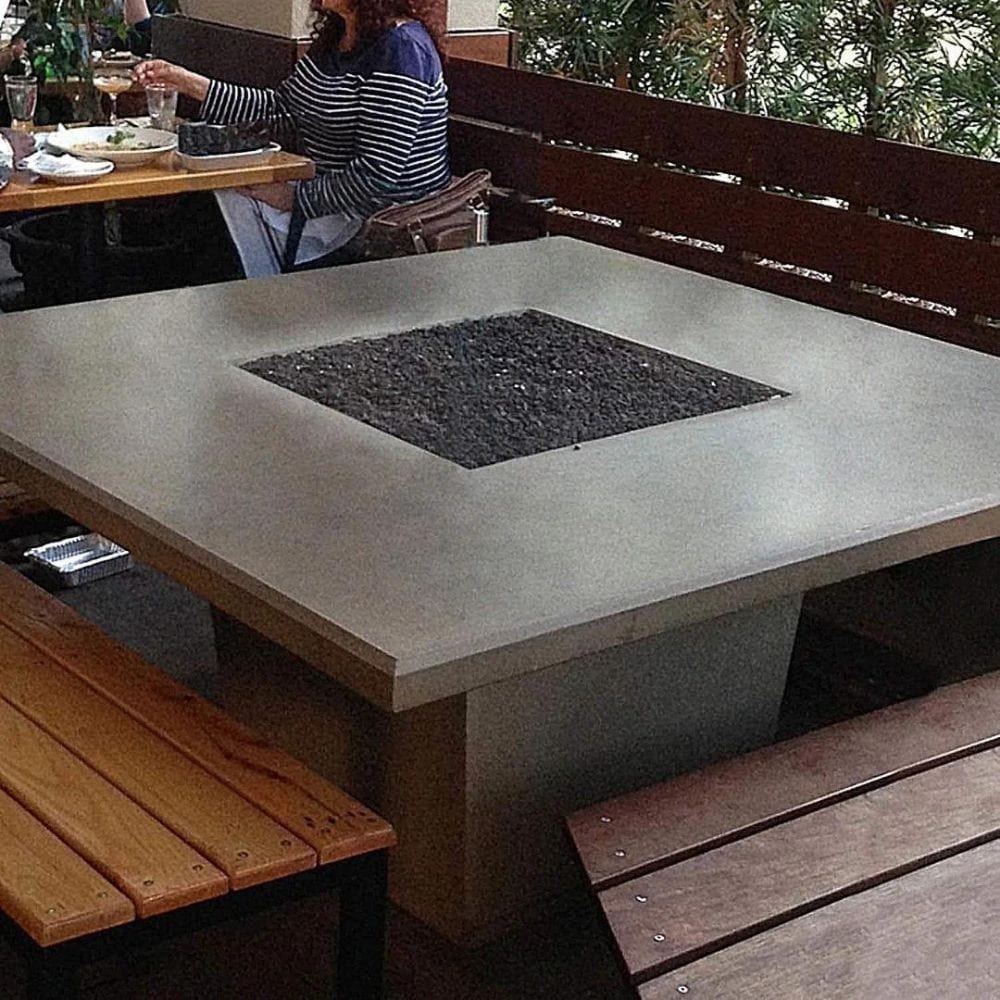 American Fyre Designs Cosmopolitan 60-Inch Concrete Square Gas Fire Pit Dining Table in Restaurant