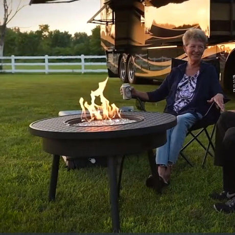 Renegade 32-inch Round Portable Gas Fire Pit Table beside the RV