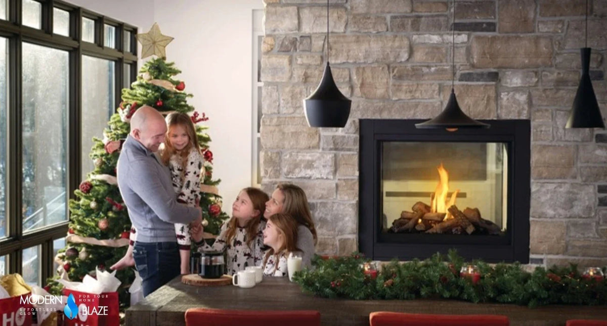Family beside a stone fireplace decorated for Christmas with an evergreen garland across the mantel and a lit tree