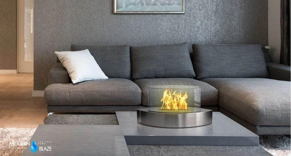 Tabletop ethanol fireplace burning on a coffee table in a gray living room