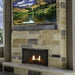 hayloft beam weathered grey mantel above an outdoor fireplace