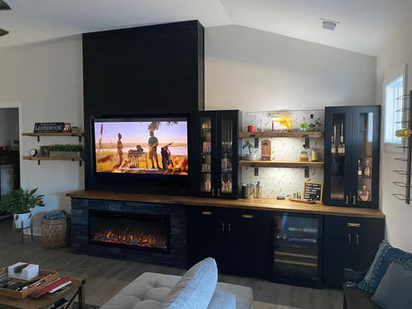Living room with a television, fireplace, and bar area.