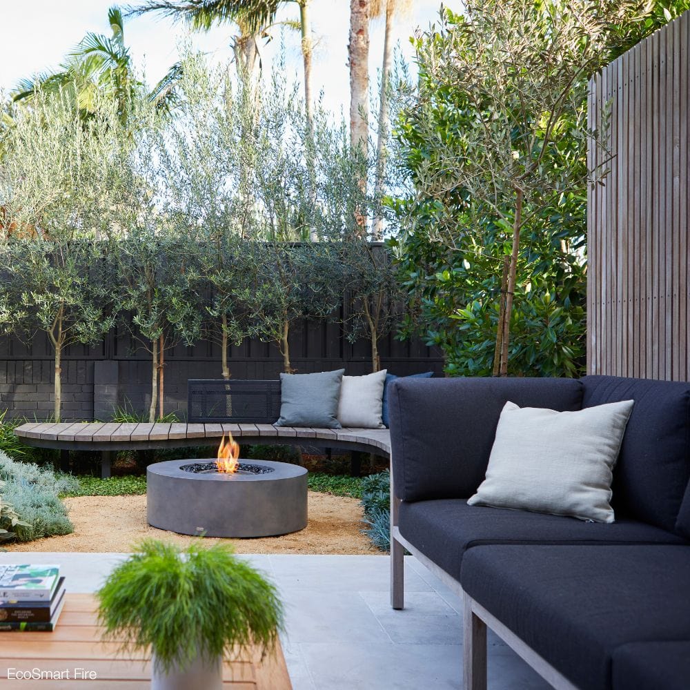 EcoSmart Fire Ark 39-Inch Round Concrete Gray Fire Pit Table in a cozy patio setting