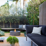 EcoSmart Fire Ark 39-Inch Round Concrete Gray Fire Pit Table in a cozy patio setting