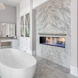 Lexington Hearth Rockface Concrete Mantel mounted on a beautiful marble wall