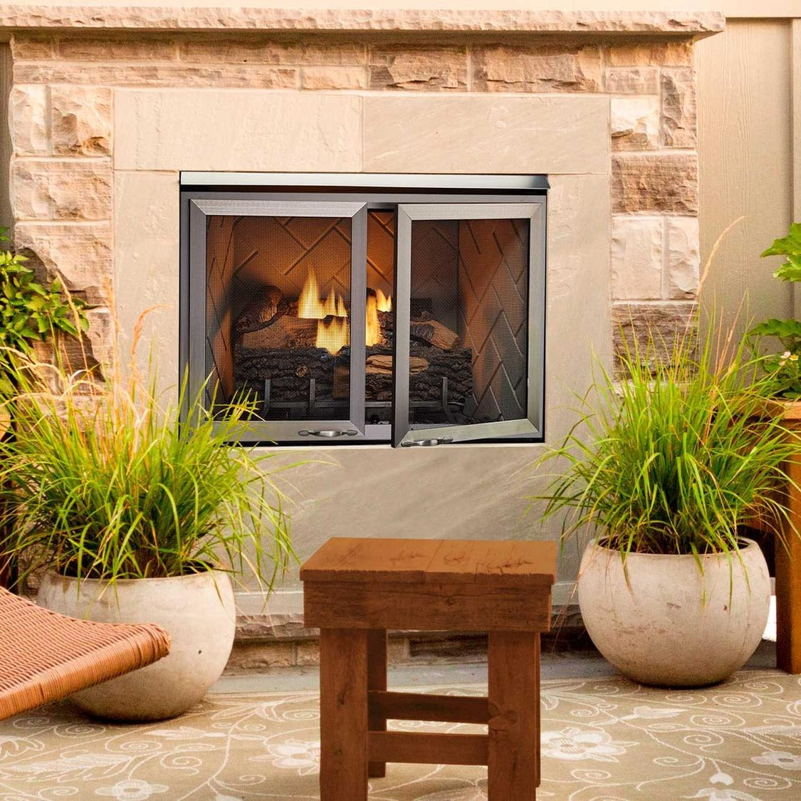 Majestic Vesper outdoor fireplace with optional mesh doors on a garden patio