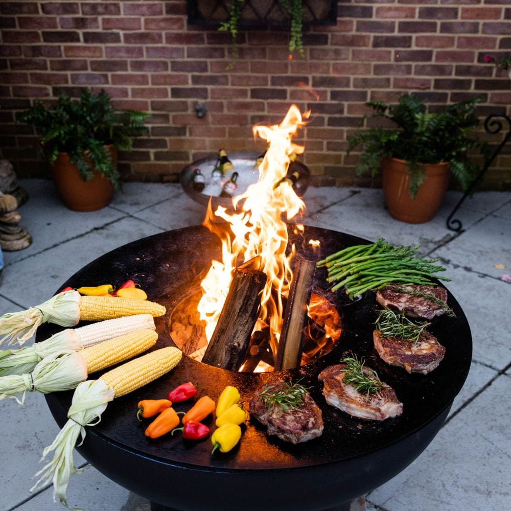seasons fire pit grill with meat, vegetables, and corn
