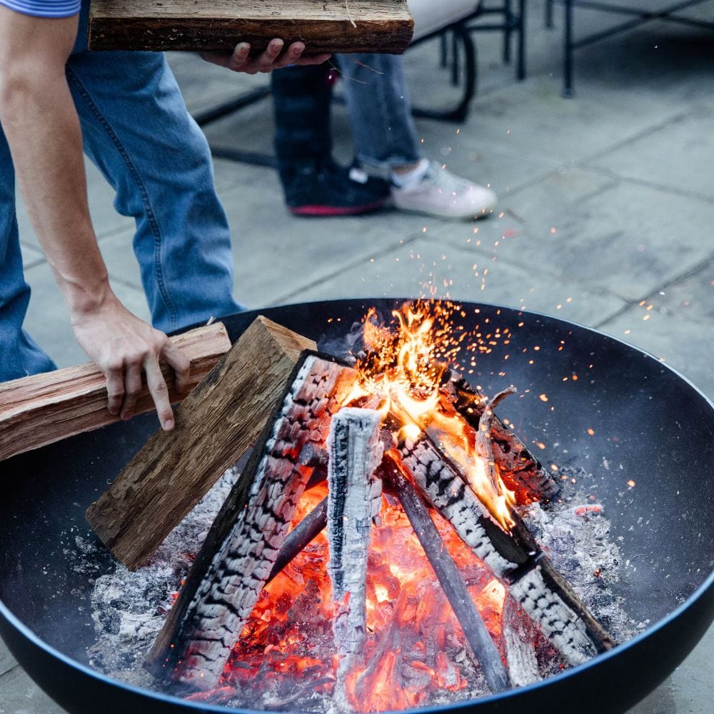 adding wood to the seasons fire pits elliptical steel fire pit