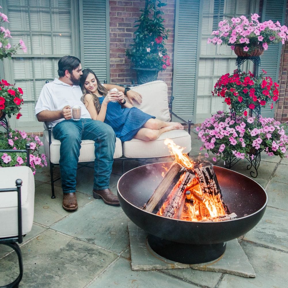 couple enjoying the seasons fire pits elliptical steel fire pit on a patio