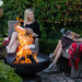 reading a book by the Seasons Fire Pits Vulcan Round Steel Fire Pit