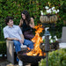 enjoying a glass of wine by the Seasons Fire Pits Vulcan Round Steel Fire Pit