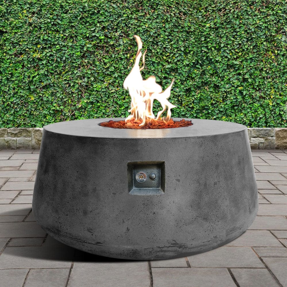 Stonelum Indiana 01 47-Inch Round Graphite Gas Fire Pit in a garden