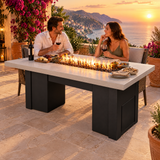 Couple sharing wine on a Mediterranean villa terrace around a Top Fires Alameda 72-inch GFRC gas fire table with a Limestone tabletop and Black base