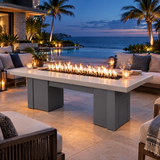 Top Fires Alameda 72-inch GFRC gas fire table with a Limestone tabletop and Gray base on a luxury poolside patio at blue hour