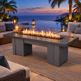 Top Fires Alameda 72-inch GFRC gas fire table with a Metallic Slate tabletop and Gray base on a luxury poolside patio at blue hour