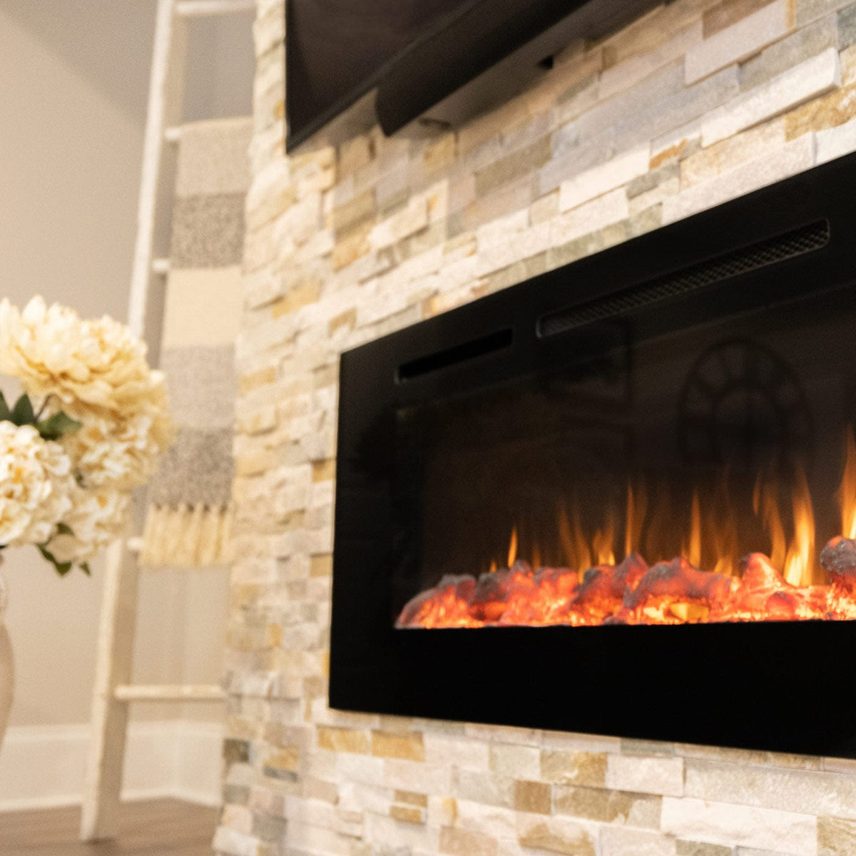 Close-up of the Touchstone Sideline 60 electric fireplace flames against a stacked stone wall