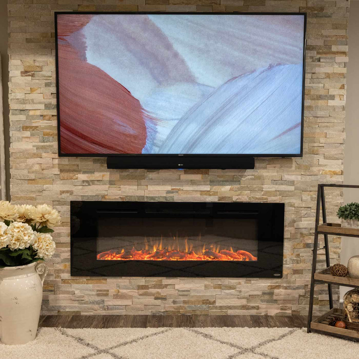 Touchstone Sideline 60 electric fireplace recessed in a stacked stone wall below a wall mounted TV