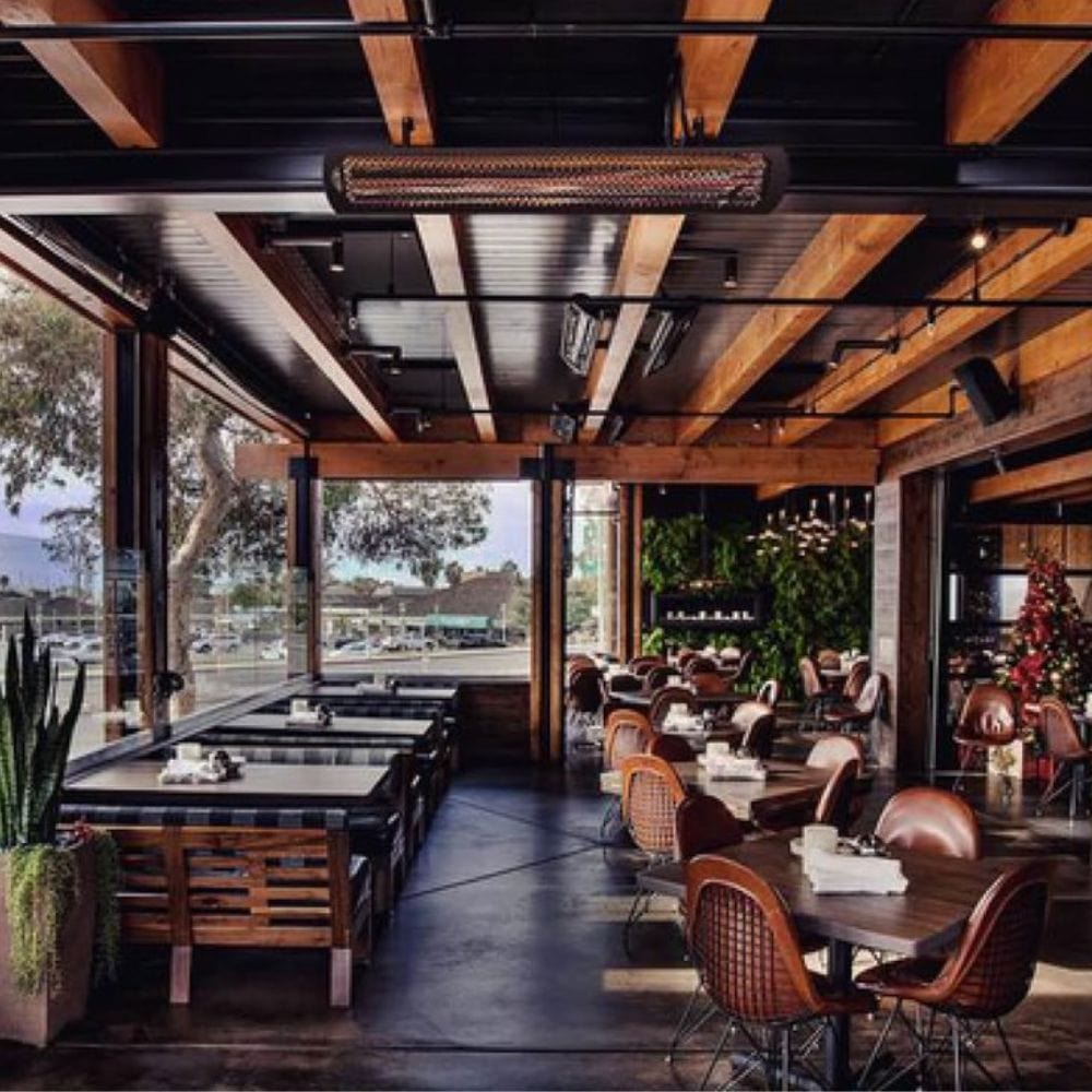 Black bromic tungsten smart-heat electric patio heater ceiling mounted in a semi enclosed patio