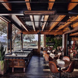Black bromic tungsten smart-heat electric patio heater ceiling mounted in a semi enclosed patio