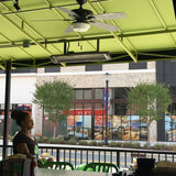 Black bromic tungsten smart-heat electric patio heater mounted overhead at a cafe