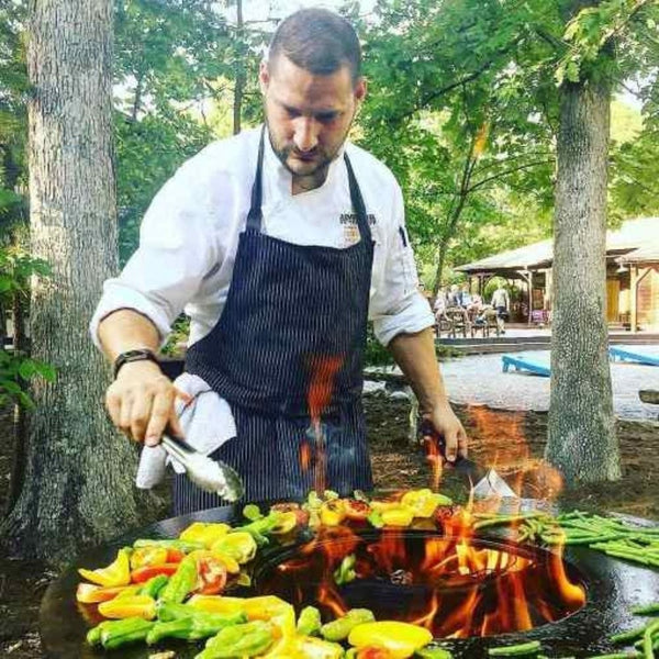 Grilling vegetables on the Arteflame 20" Tall Euro Base Corten Steel Fire Pit with Cooktop