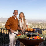 Cooking a family meal on a Arteflame 20-Inch Tall Euro Base Fire Pit with Cooktop