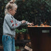 a kid grilling on the arteflame one series 20-inch fire pit