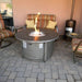 AZ Patio Heaters Brushed Wood Aluminum 44" Round Gas Fire Pit Table with Round Burner and Fireglass in Patio setting