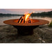 Fire Pit Art Magnum - 54" Handcrafted Carbon Steel Fire Pit (MAG) Lit Up Beside A Lake