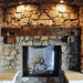 olde wood rough sawn wooden fireplace mantel on stone wall