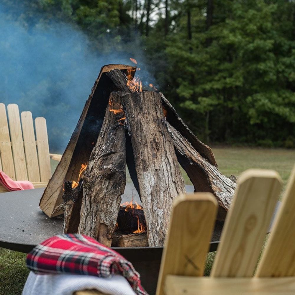 wood stacked tee pee style on season fire pits concave fire pit