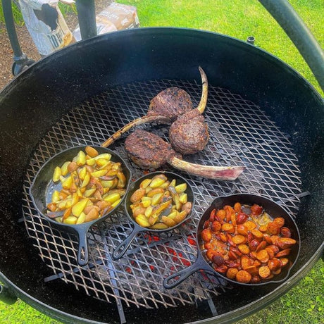 grilling steak and potatoes on the cowboy cauldron fire pit grill