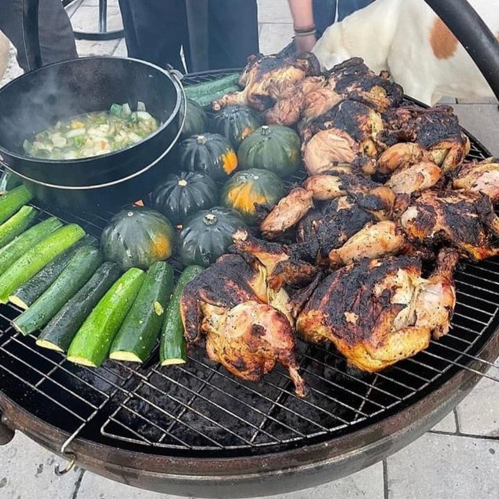 grilling meat and vegetables on the cowboy cauldron fire pit grill at the backyard