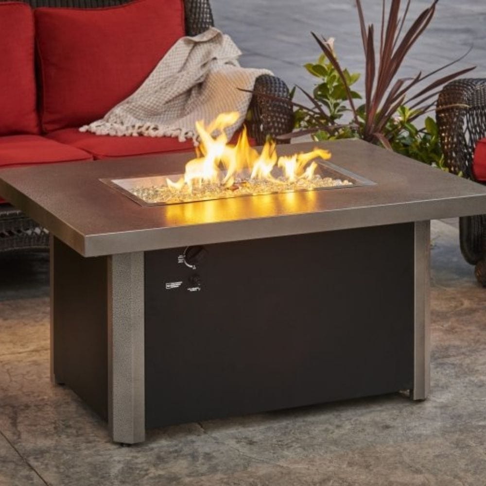 The Outdoor GreatRoom Company Caden 44" Rectangular Fire Pit Table beside couches