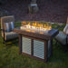 Denali Brew 57" Linear Gas Fire Pit Table in back yard with wind guard