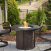 The Outdoor GreatRoom Company Stonefire brown Round Fire Pit Table in outdoor area